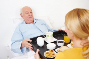 nurse serving food to an elderly man